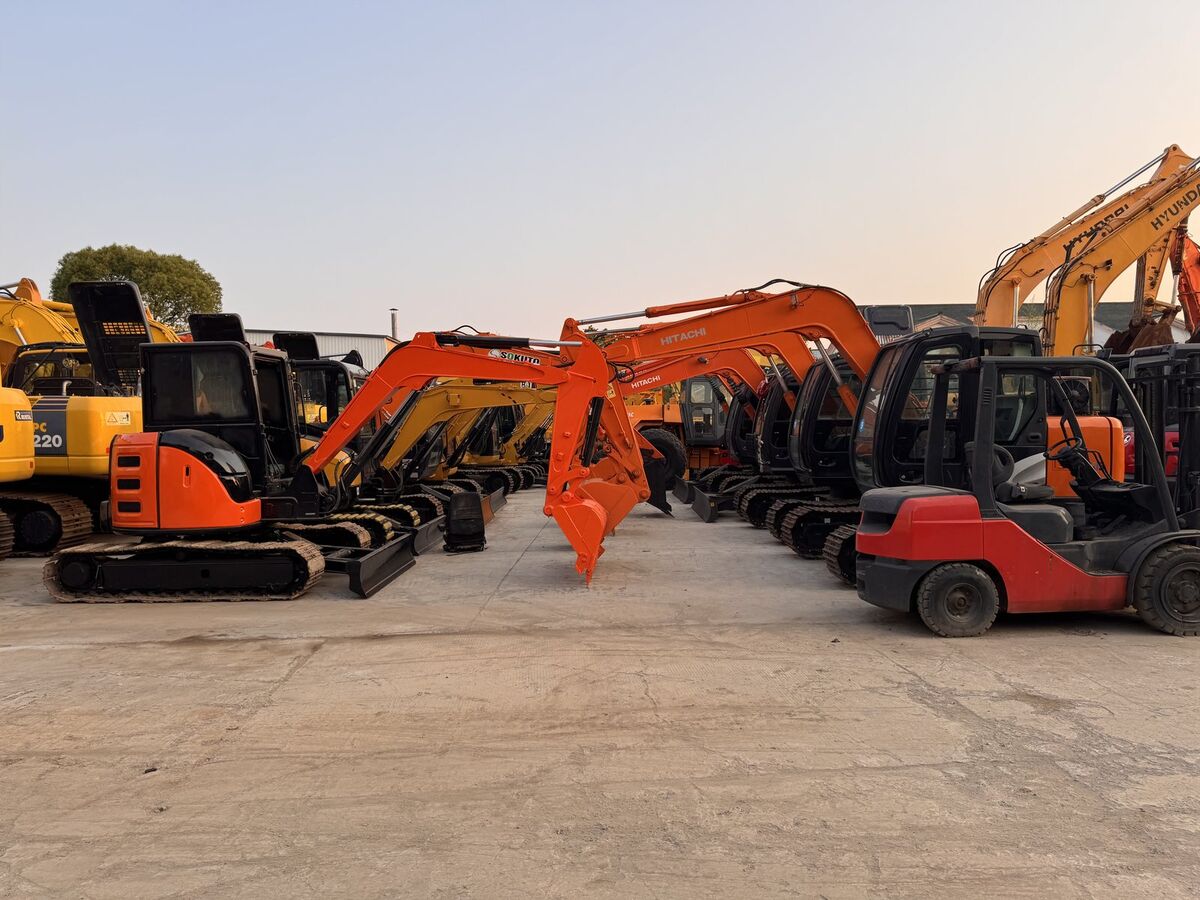 Dense equipment yard — mini excavators, forklifts, and attachments